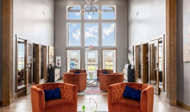 a living room with a chandelier and chairs